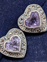 Front view of both heart-shaped amethyst and marcasite earrings on fabric