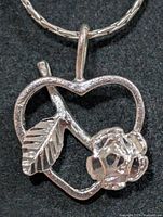 Pendant close-up showing heart, leaf, rose design