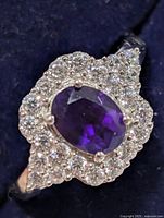 Close-up of ring face showing oval amethyst and CZ halo