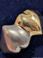 Close-up of gold-tone heart accent joined to silver band