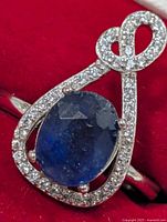Front view of silver ring showing sapphire center and CZ halo