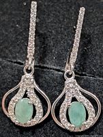 Front view of both earrings showing emerald centres and CZ pave