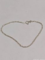 Full view of silver rope chain bracelet laid flat