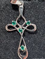 Front view of silver Celtic cross pendant with green stones