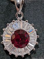 Front view of pendant showing ruby center and CZ halo