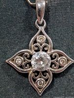 Front view of silver filigree pendant with central and accent CZ stones