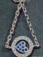 Front view of pendant showing circle halo and blue heart stones