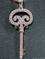Front view of silver CZ key pendant