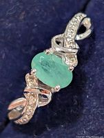 Top view of ring showing emerald and accent stones