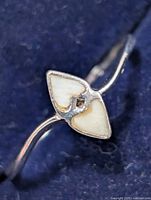 Close view of ring face showing mother of pearl inlay and center stone