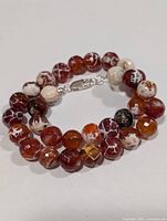 Coiled view of entire fire agate bead necklace with clasp visible