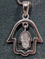 Front view of silver hamsa pendant showing overall design