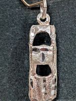 Top view of car shaped silver pendant