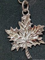Front view of silver maple leaf pendant showing texture and jump ring