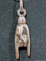Front view of silver pendant showing hand gesture and bail