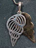 Front view showing openwork silver-tone element over gold-tone backing