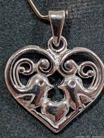 Front view of heart pendant showing bird and scroll design