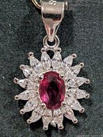 Front view of pendant showing ruby center and CZ halo