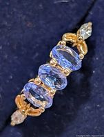 Side angled view showing four tanzanite stones and marquise accent