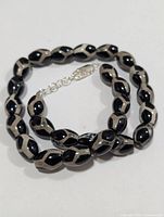 Coiled view of full bead necklace showing clasp and extension chain