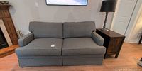Front view of grey tweed sofa with pillows