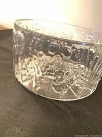 Side view of clear glass bowl showing embossed Flora pattern