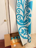 Rug leaning against wall with box of patio lights visible