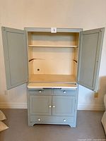 Front view of robin-egg blue larder cupboard with doors open displaying interior shelf, drawers and lower cabinet