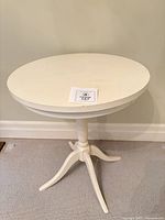 Full view of off-white round pedestal side table