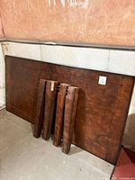 tabletop and four detached legs leaning against wall