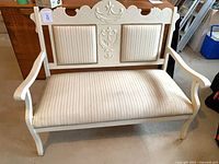 Front view showing carved crest, arms, striped upholstery