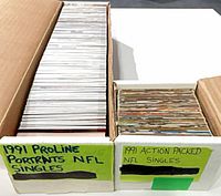Two open card boxes showing large stack labeled 1991 ProLine Portraits NFL Singles and smaller stack labeled 1991 Action Packed NFL Singles