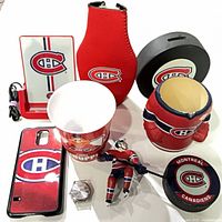 Group view of all Montreal Canadiens items including charger, koozie, cup, phone case, watch head, ornament, puck, piggy bank, wrist band and pouch