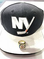 Hat front with ring set on brim showing logos and scale