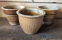 All three ceramic pots on workbench