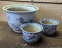 All three porcelain planters showing relative sizes and decoration
