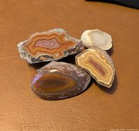 Group shot of four banded agate pieces showing size range and polished faces