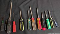 12 screwdrivers lined up on black cloth
