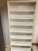 Front view of entire white bookcase showing seven shelves