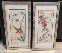 Both framed paintings standing side by side to show complete lot