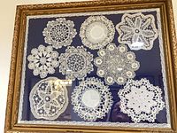 Full view of framed lace doily display
