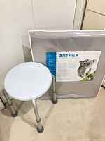 Shower stool beside packaged Orthex pillow