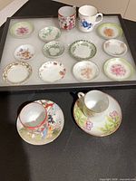 All teacups, saucers and butter pats arranged for overview
