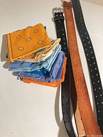 Belts alongside stacked bandanas