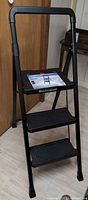 Full view of black three-step folding stool