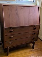 Full view of teak drop-front desk showing drawers and legs