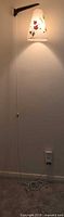 Full view of wall-mounted lamp, cord extending to outlet