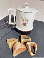 Kettle on base with floral design and four triangular napkin holders