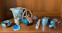 Group shot of teapots, creamers, thermometer and strainers