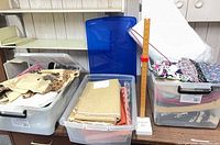 Three bins of fabric, white batting bag, Singer skirt marker